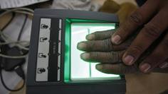 FILE PHOTO - A villager goes through the process of a fingerprint scanner for the Unique Identification (UID) database system at an enrolment centre at Merta district in the desert Indian state of Rajasthan February 22, 2013. REUTERS/Mansi Thapliyal
