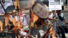 Activists burn an effigy of Philippine President Benigno Aquino to denounce his government for not taking more action in the case of Filipina drug convict Mary Jane Veloso during a protest outside the presidential palace in Manila April 29, 2015. REUTERS/