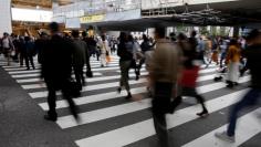 FILE PHOTO: Commuters cross a pedestrian crossing in Osaka, Japan October 24, 2017.   REUTERS/Thomas White/File Photo     