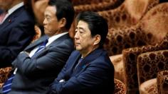 FILE PHOTO - Japan's Prime Minister Shinzo Abe (R) sits next to Deputy Prime Minister and Finance Minister Taro Aso as they attend a lower house budget committee session at the parliament in Tokyo, Japan July 24, 2017.  REUTERS/Toru Hanai
