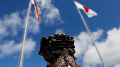 FILE PHOTO - The U.S. (L) and Japanese national flags are hoisted next to a traditional Okinawan Shisa statue at the U.S. Marine's Camp Foster in Ginowan, on the southern island of Okinawa, Japan June 18, 2016. REUTERS/Tim Kelly 
