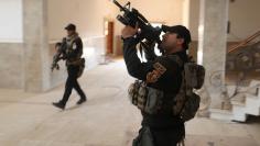 Iraqi special forces soldiers search a building located inside a church compound in Bartella, east of Mosul, Iraq