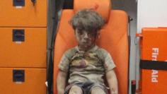 Five-year-old Omran Daqneesh, with bloodied face, sits inside an ambulance after he was rescued following an airstrike in the rebel-held al-Qaterji neighbourhood of Aleppo