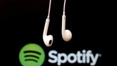 Headphones are seen in front of a logo of online music streaming service Spotify in this  February 18, 2014 illustration picture. REUTERS/Christian Hartmann/File Photo