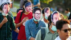 A protester wearing a mask of Reuters journalist Wa Lone (C) takes part in a demonstration demanding his release at Inya lake bank in Yangon, Myanmar, January 20, 2018. REUTERS/Stringer