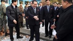 Head of North Korean delegation Ri Son Gwon, Chairman of the Committee for the Peaceful Reunification of the Country (CPRC) of DPRK, reaches out to shake hands with a South Korean official as he crosses a concrete border to attend their meeting at the tr