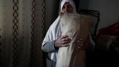 Ezzeya Daraghmeh, an 82-year-old Palestinian woman who said she has kept parts of her hair she cut over 67 years, holds a pillow that she stuffed with her hair, in the West Bank town of Tubas