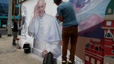 Artists paint a mural of Pope Francis prior to the Pope's arrival to Lima