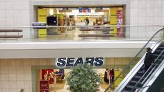 A woman pushes a pushchair past the the Sears department store at Fair Oaks Mall in Fairfax