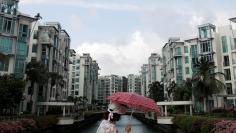 FILE PHOTO: A woman passes a private condominium estate in Singapore February 13, 2017. REUTERS/Edgar Su/File Photo