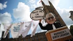 FILE PHOTO: A protester depicting media magnate Rupert Murdoch demonstrates opposite the Houses of Parliament in London, September 12, 2017. REUTERS/Hannah McKay/File Photo