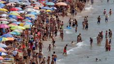 FILE PHOTO: People enjoy the beach in the southeastern city of Benidorm, Spain, July 31, 2017. REUTERS/Heino Kalis/File Photo