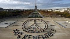 FILE PHOTO: Hundreds of environmentalists arrange their bodies to form a message of hope and peace in front of the Eiffel Tower in Paris, France, December 6, 2015, as the World Climate Change Conference 2015 (COP21) continues at Le Bourget near the Frenc