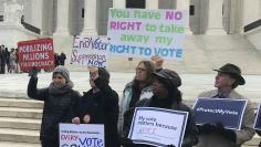 Activists rally outside the U.S. Supreme Court ahead of arguments in a key voting rights case involving a challenge to the OhioÕs policy of purging infrequent voters from voter registration rolls, in Washington, U.S., January 10, 2018. REUTERS/Lawrence 