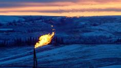 A natural gas flare on an oil well pad burns as the sun sets outside Watford City, North Dakota January 21, 2016. REUTERS/Andrew Cullen 