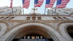 Flags fly above the entrance to the new Trump International Hotel on its opening day in Washington