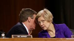Senators Mark Warner (D-VA) and Elizabeth Warren (D-MA) speak before Federal Reserve Chair Janet Yellen testifies before a Senate Banking, Housing, and Urban Affairs Committee hearing on the “Semiannual Monetary Policy Report to the Congress” on Capi