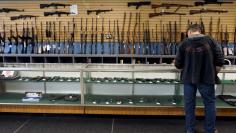 FILE PHOTO: A customer looks over weapons for sale at the Pony Express Firearms shop in Parker