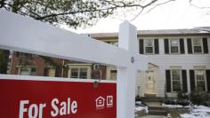 A home for sale sign hangs in front of a house in Oakton in Virginia March 27, 2014.    REUTERS/Larry Downing
