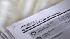 FILE PHOTO - The federal government forms for applying for health coverage are seen at a rally held by supporters of the Affordable Care Act, widely referred to as "Obamacare", outside the Jackson-Hinds Comprehensive Health Center in Jackson, Mississippi
