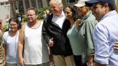 U.S. President Donald Trump and first lady Melania Trump pose with residents while surveying hurricane damage in San Juan, Puerto Rico, U.S., October 3, 2017. REUTERS/Jonathan Ernst