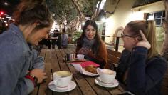 DACA recipient Martha Valenzuela (C), 23, sits in a coffee shop with friends Courtney Folsom (L), 24, and Mariah Osborn, 22, in Fullerton, California, U.S., January 25, 2018. REUTERS/Lucy Nicholson     