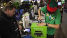 A man buys an XBOX One video game console at a Toys"R"Us store during their Black Friday Sale in New York November 28, 2013.     REUTERS/Carlo Allegri (UNITED STATES - Tags: BUSINESS) - RTX15WXX