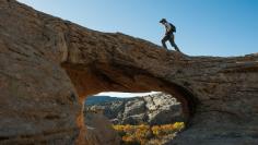 FILE PHOTO: A man walks over a natural bridge at Butler Wash in Bears Ears National Monument near Blanding