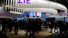 FILE PHOTO: People stand at ZTE's booth during Mobile World Congress in Barcelona, Spain, February 27, 2017. REUTERS/Paul Hanna/File Photo