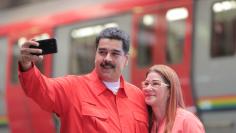 Venezuela's President Nicolas Maduro takes a selfie next to his wife Cilia Flores as they arrive for a rally with workers of transport sector in Caracas, Venezuela January 24, 2018. Miraflores Palace/Handout via REUTERS