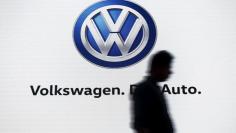 A man walks past a screen displaying a logo of Volkswagen at an event in New Delhi, India, June 23, 2015.  REUTERS/Anindito Mukherjee