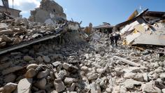 Rescuers work on collapsed buildings following an earthquake in Amatrice