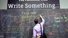 An employee writes a note on the message board at the new headquarters of Facebook in Menlo Park, California on January 11, 2012. The 57-acre campus, which formerly housed Sun Microsystems, features open work spaces for nearly 2,000 employees on the one m