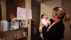 Doreen Earp, 38, of Germany looks at her five-week-old daughter Emily in their apartment at Hope Gardens Family Center, which is run by Union Rescue Mission on 77 acres of countryside near Los Angeles, California.         