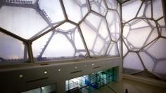 A worker looks up at the honeycomb-shaped walls of the National Aquatics Centre, also known as the "Water Cube", which was the venue for the 2008 Beijing Olympic Games swimming and diving competitions in Beijing March 27, 2012. The gigantic infrastructure