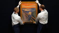 Sotheby's employees pose with Edvard Munch's "The Scream" at the auction house in London, April 12, 2012. The painting, estimated to exceed $80 million (50.2 million pounds), broke a world record in New York on May 2, 2012, becoming the most expensive pai